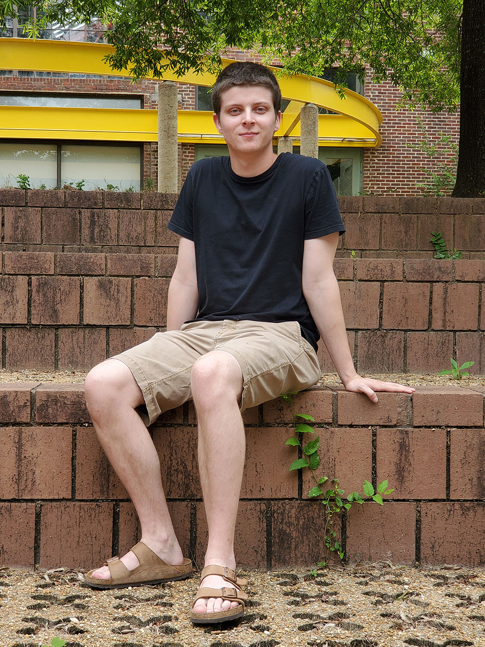 John Spraberry sits in the amphitheater area outside of Giles Hall