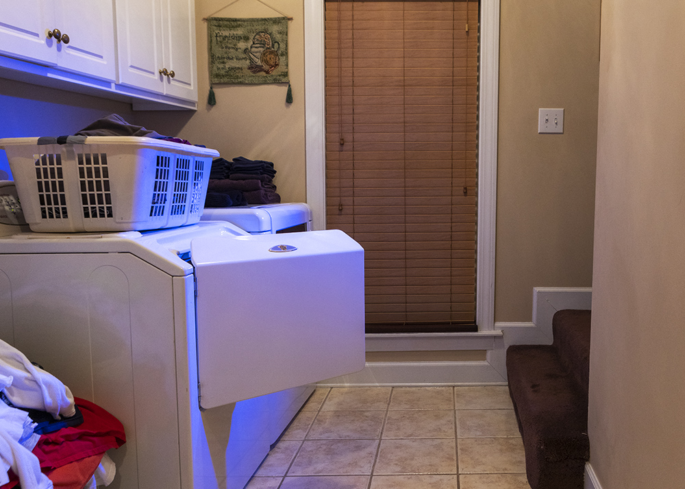 A photograph of an open washing machine with a blue radiant light 