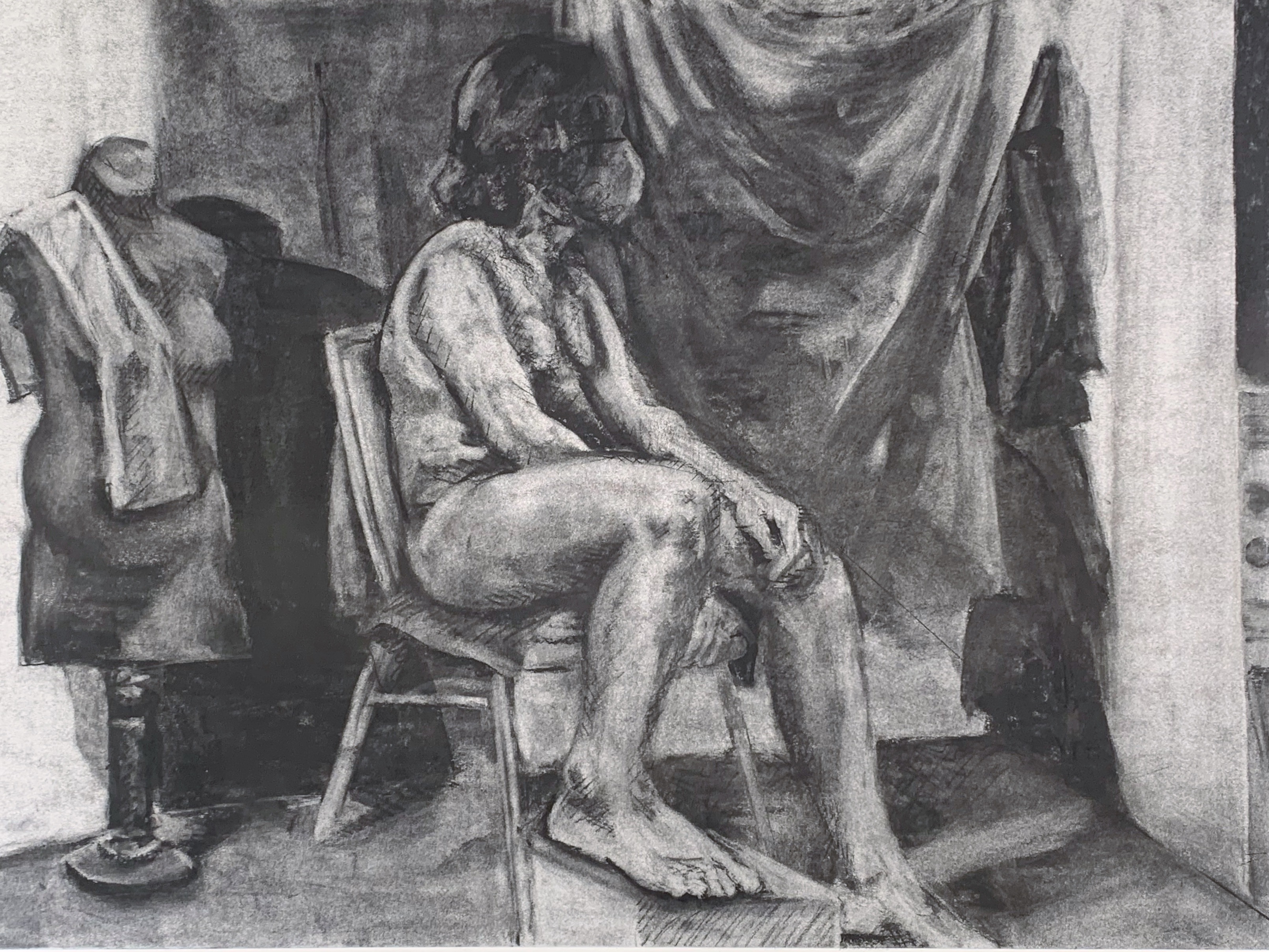 A charcoal drawing of a human model, using the reductive value technique to reveal light within the drawing. 