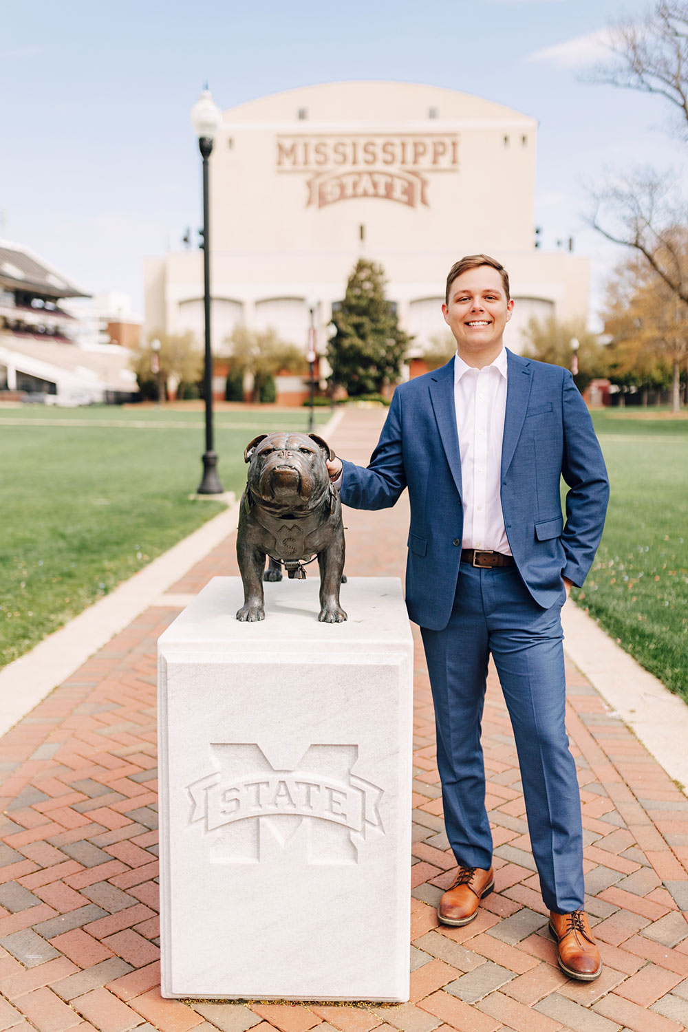 Baron Necaise stands to right of Bully statue with MSU stadium in background