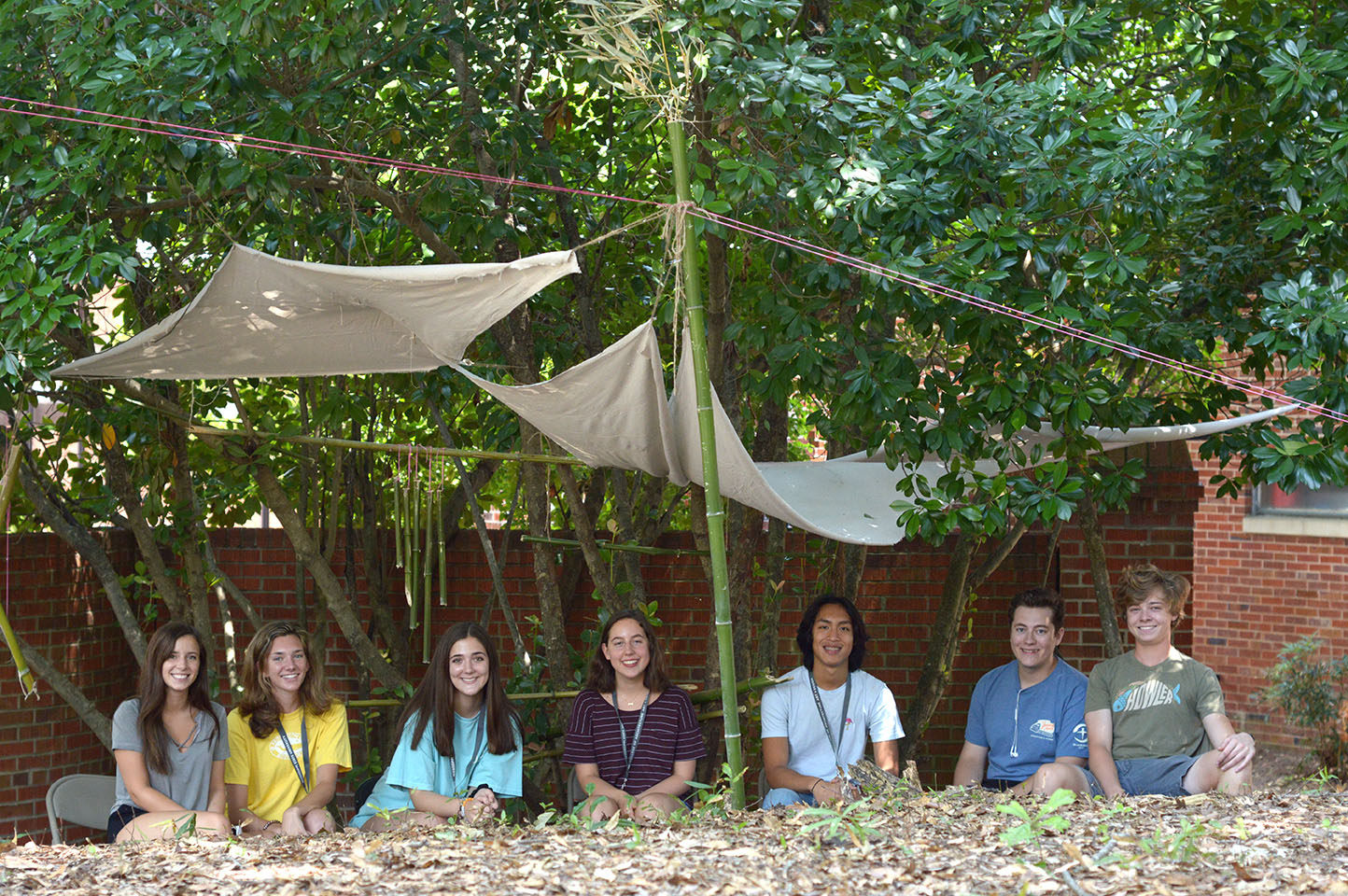 group of students sitting under shelter