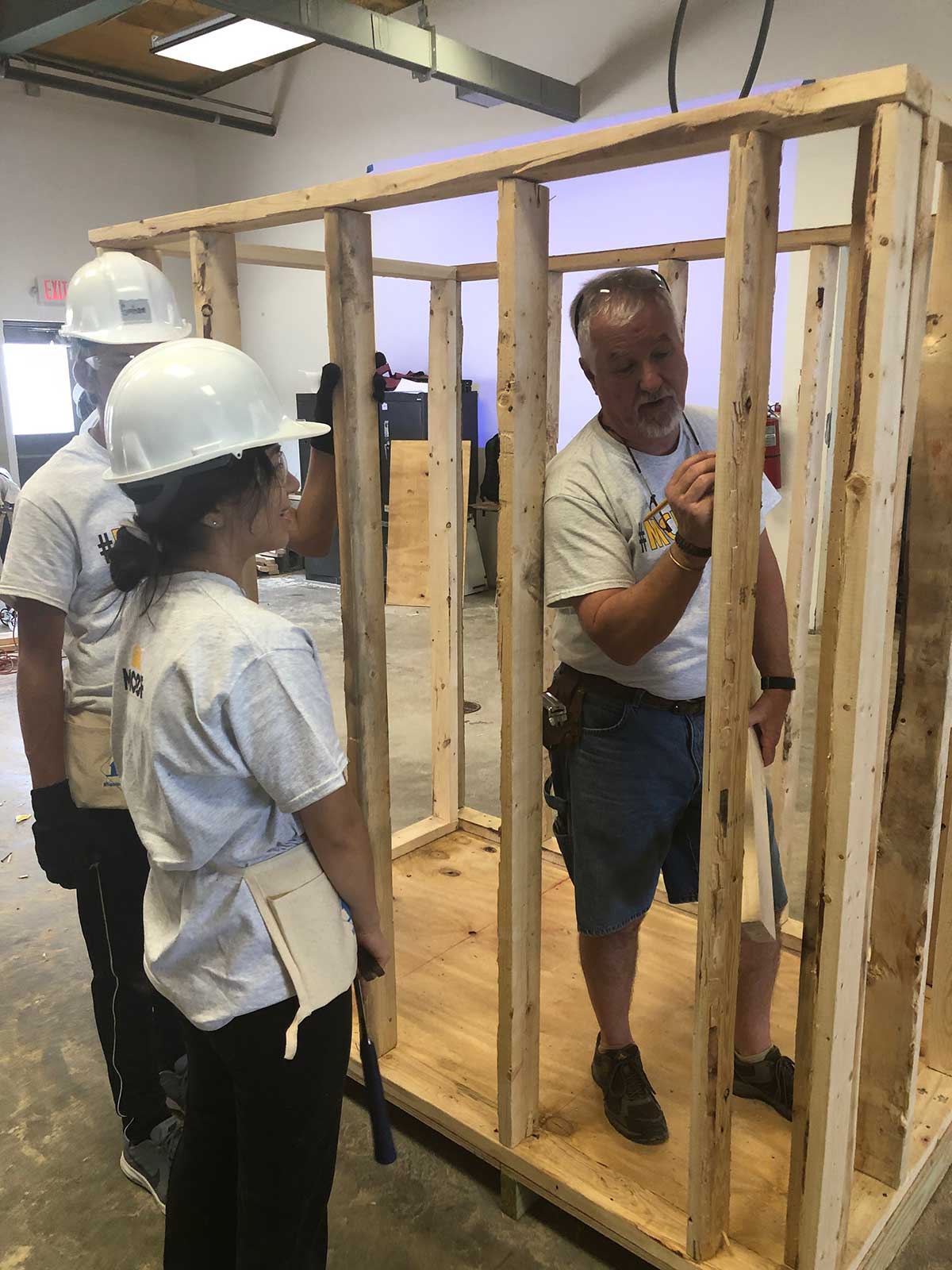 campers work on framing shooting house