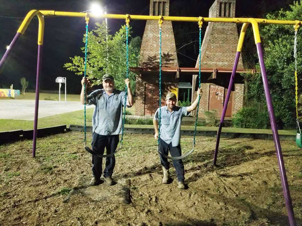 two men at swing set at night