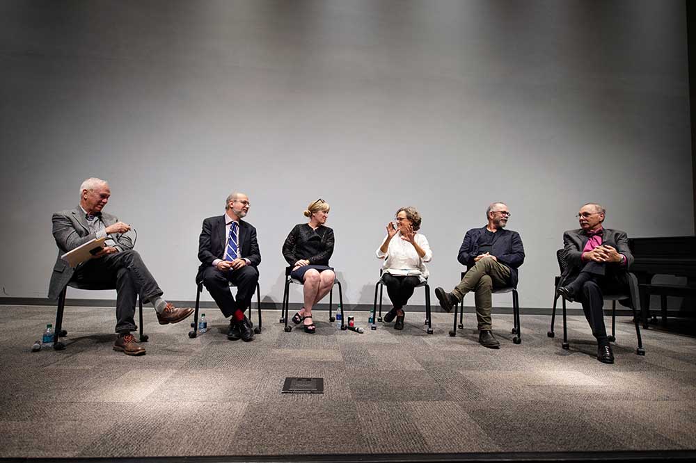Panelists (seated, l-r) include John McRae, John Poros, Kimberly Brown, Shannon Criss, Nils Gore, and Michael Buono.
