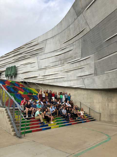 group poses in front of outside of Perot Museum in Dallas
