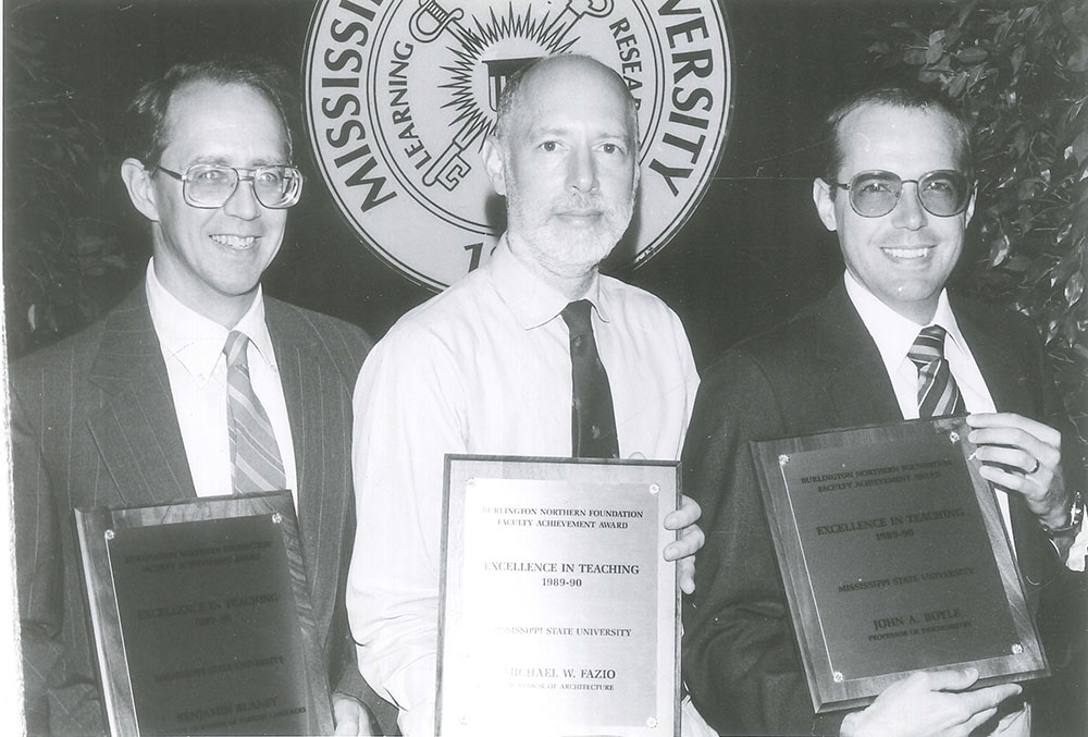 Michael Fazio, center, is shown with 2 other men holding plaques