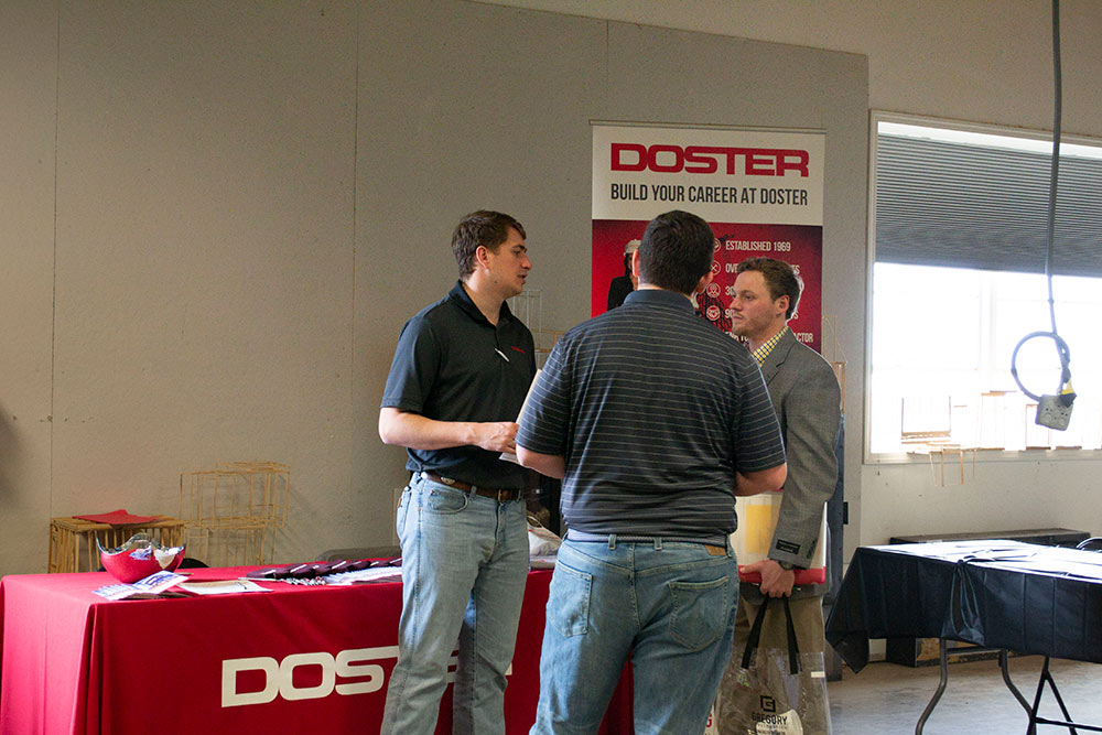 students talk with company representatives at the spring 2020 Building Construction Science Program career fair in Howell Building
