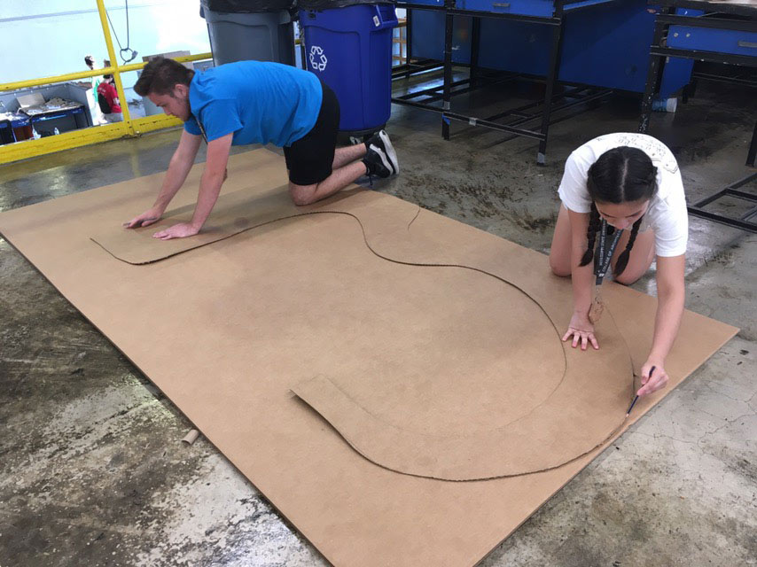 campers work to cut cardboard for their lounge device