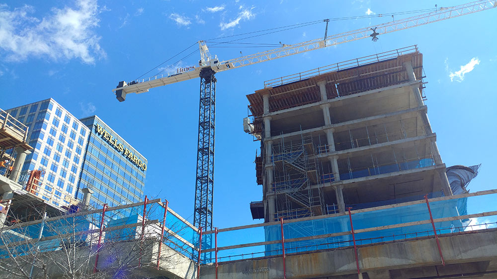 Wells Fargo building on left, crane in center, building under construction on right