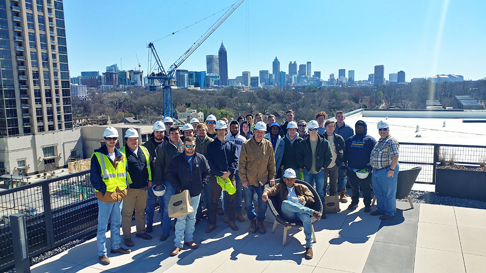 Mississippi State building construction science first-year students pose in a group in Atlanta - wearing safety vests and hard hats