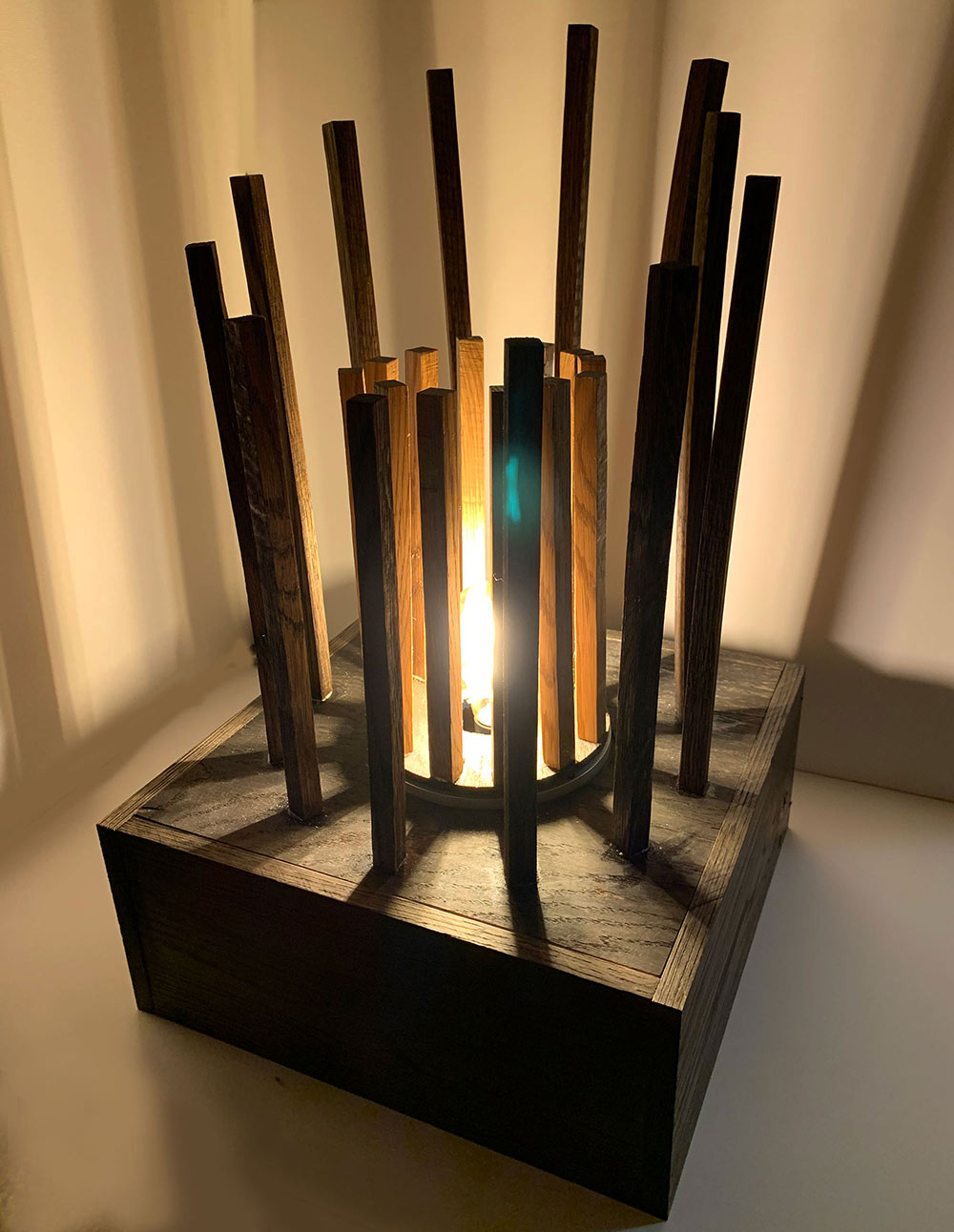 lamp with square wood base and long boards coming up in a circle around a light