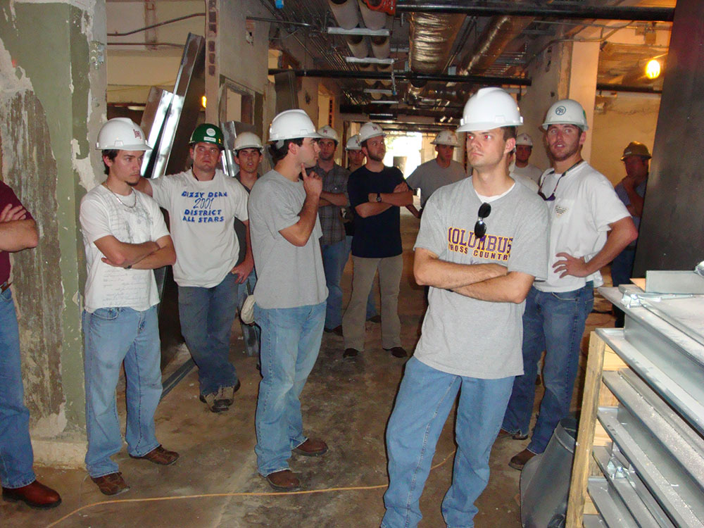 students wearing hard hats tour inside facility