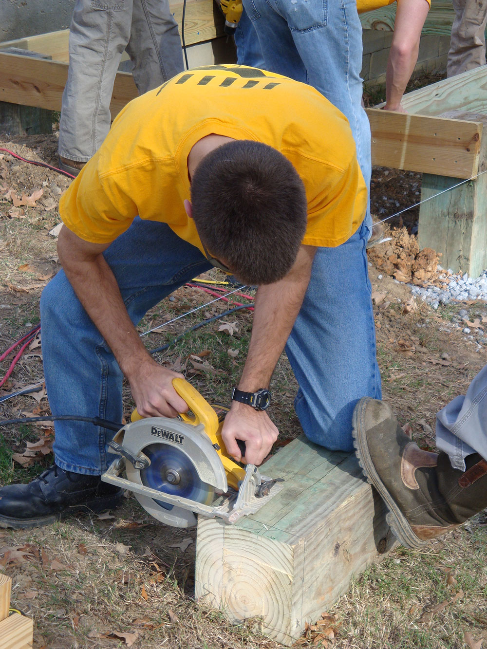 student uses saw on wood