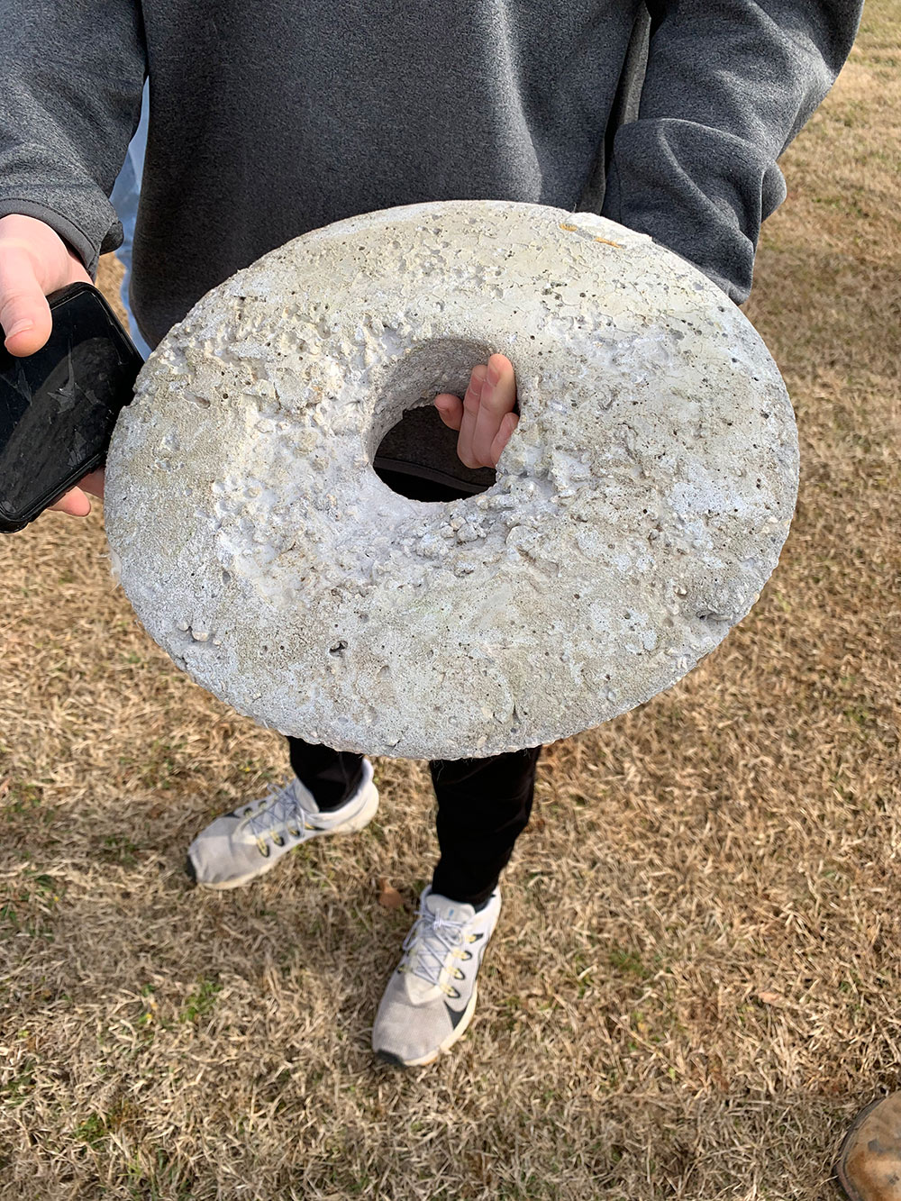 student holds concrete disk