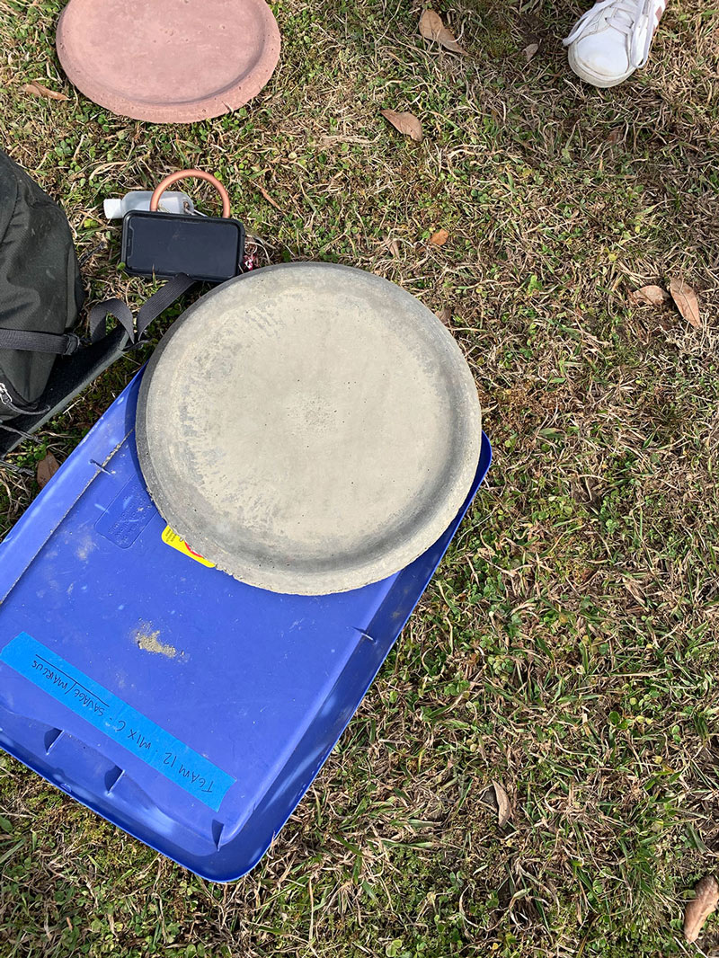 concrete disk on grass next to blue tray