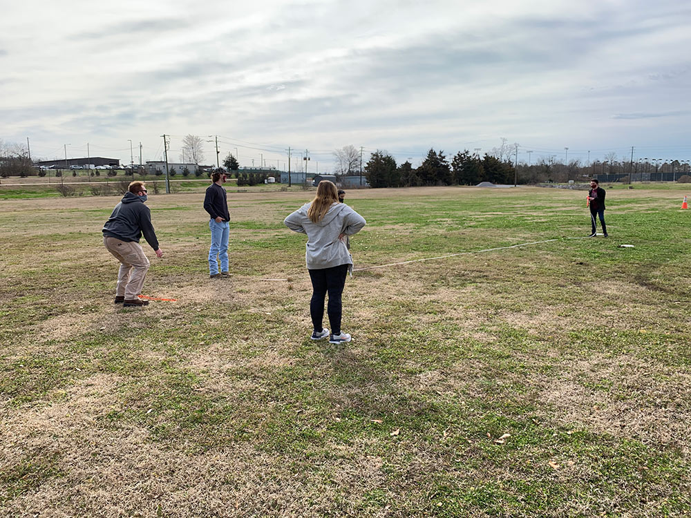 students measure distance of disk throw