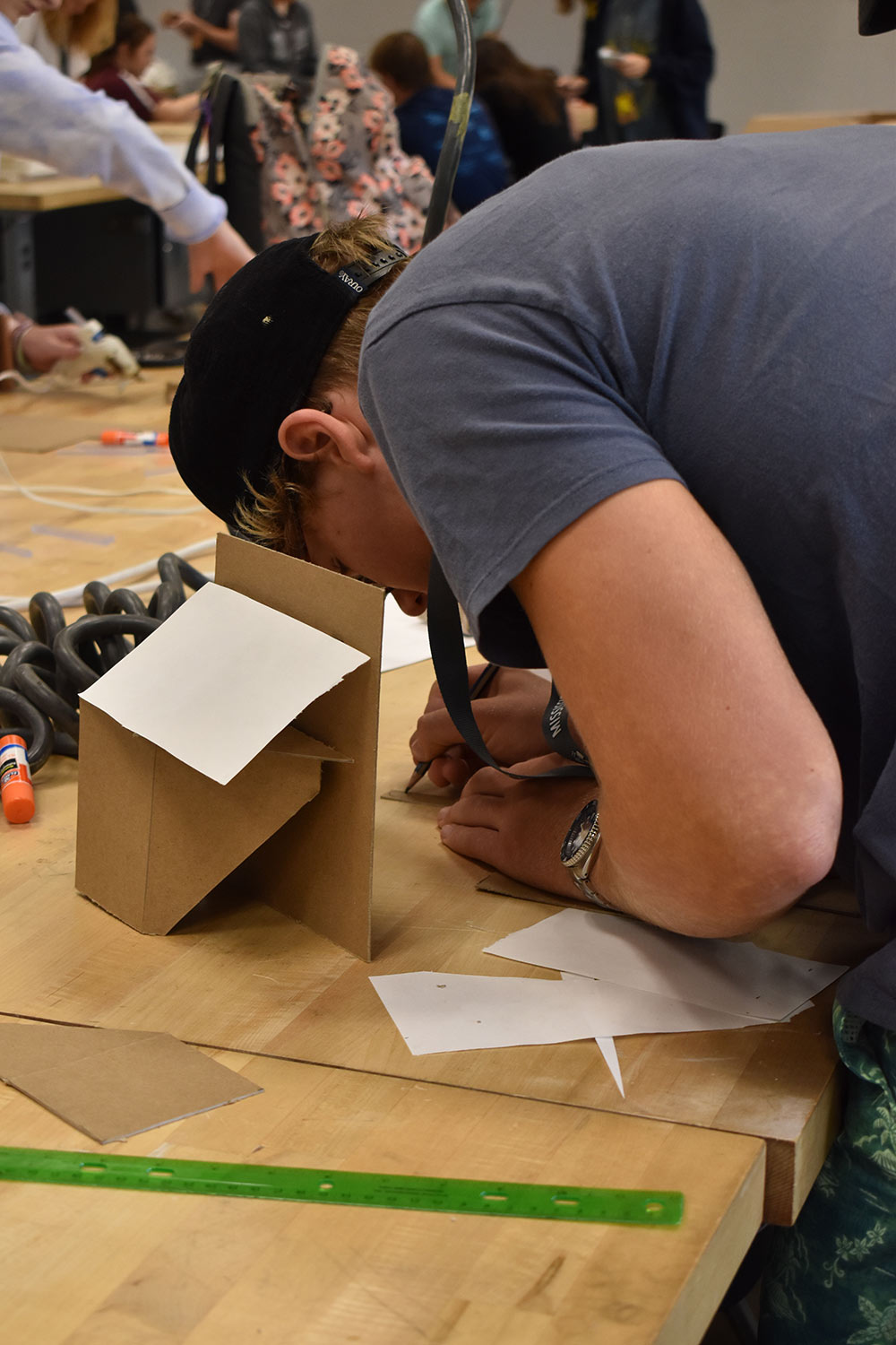 male camper works with to construct with cardboard