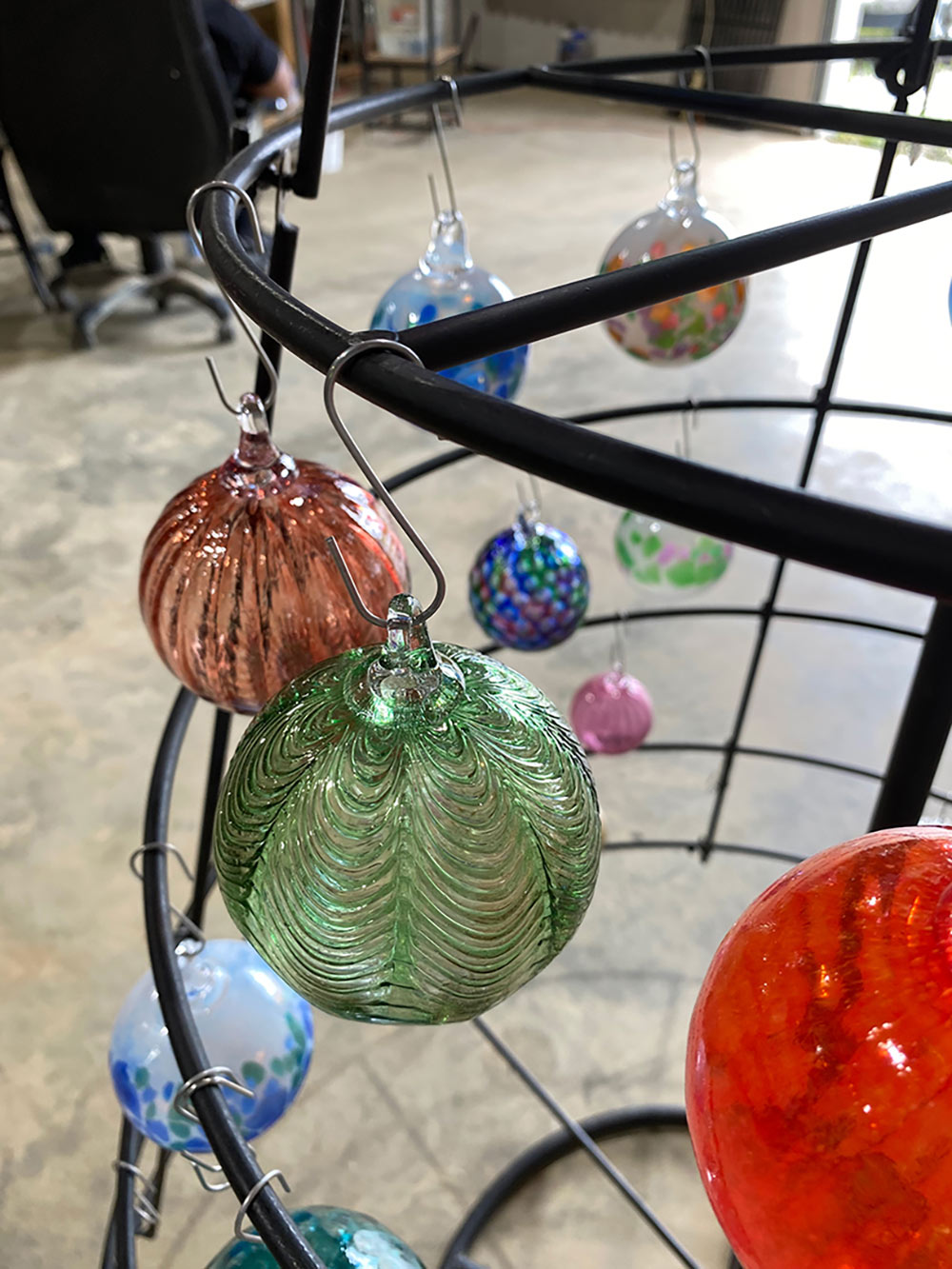 view of metal &quot;tree&quot; holding colorful glass ornaments