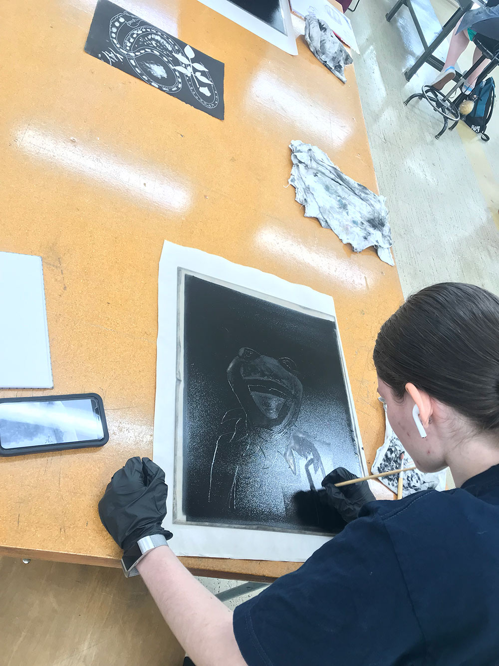 student works on monoprint project - back seen