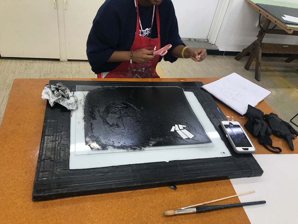 student works on monoprint project - front seen, but only shoulders down