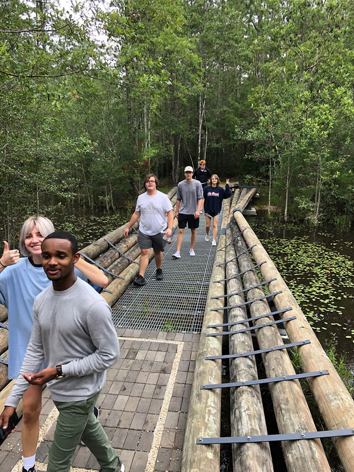 Students crossing the new Mirror Perch Bridge at the Crosby Arboretum Gum Pond exhibit. 