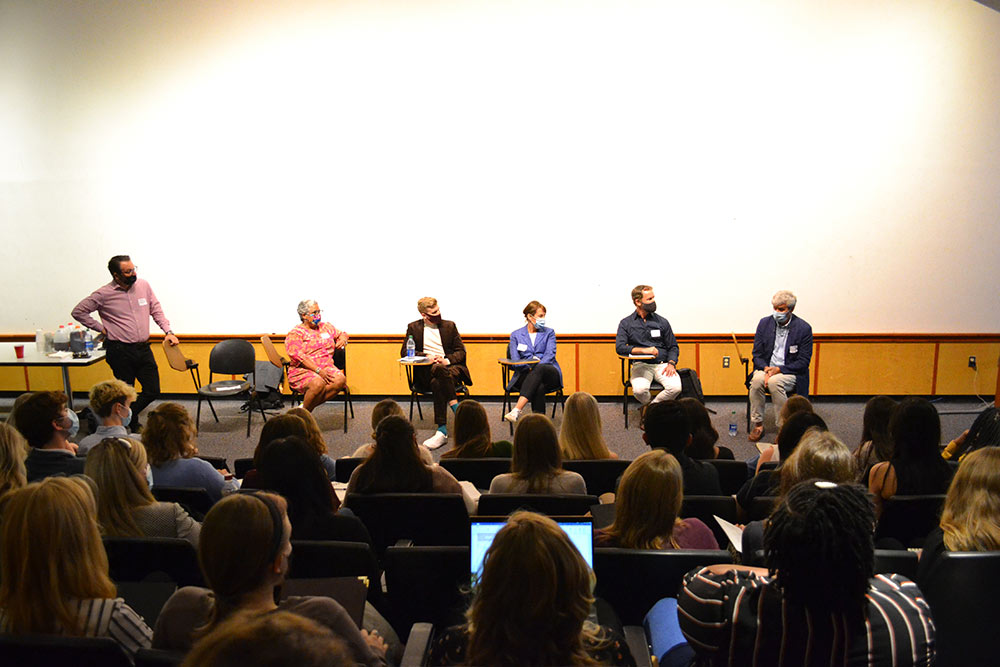 A panel of design professionals sit on stage and answer questions from a group of participants in an auditorium in Giles.
