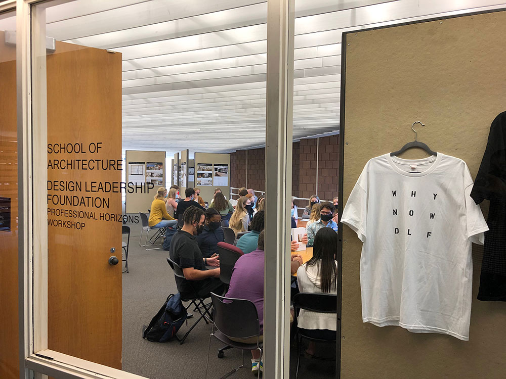 Participants of the Design Leadership Foundation’s Professional Horizons Workshop meet in the gallery in Giles. T-Shirts hang from a display.