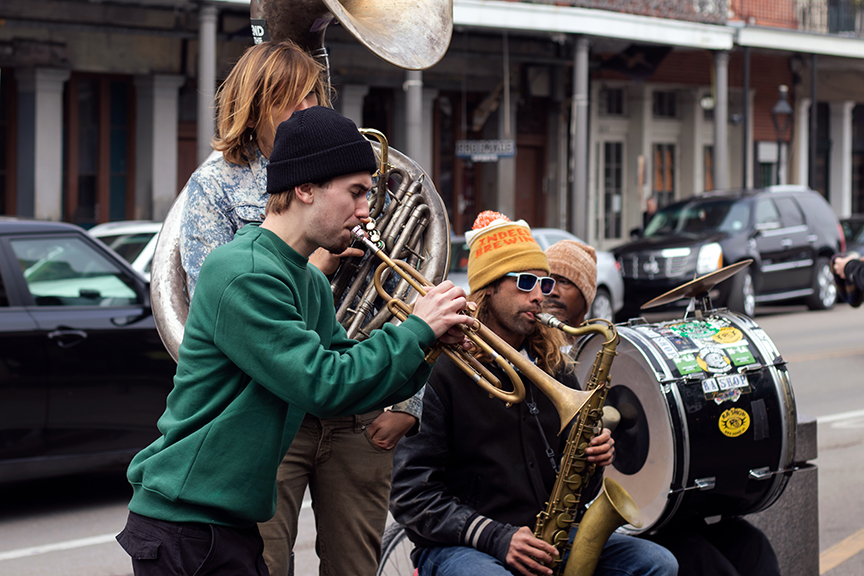 Photograph of group of musicians playing outside on the street.