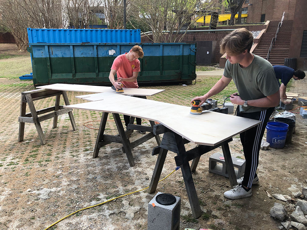 students working outside of Giles Hall on project for the Sanderson Center&#039;s Outdoor Adventures area
