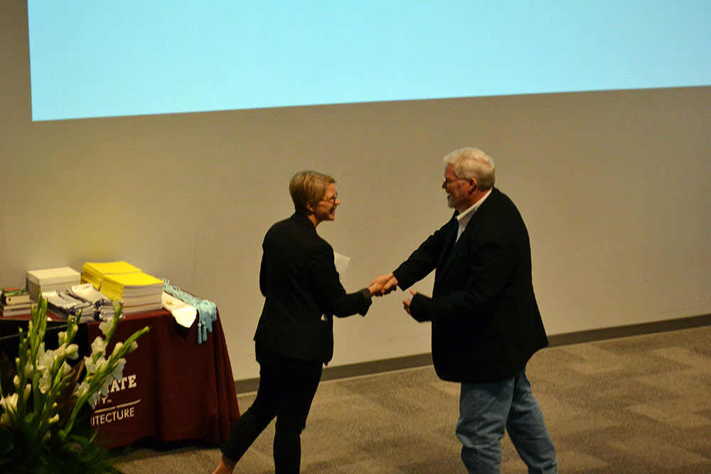 Dr. Angi Elsea Bourgeois shakes hands with Mark Vaughan