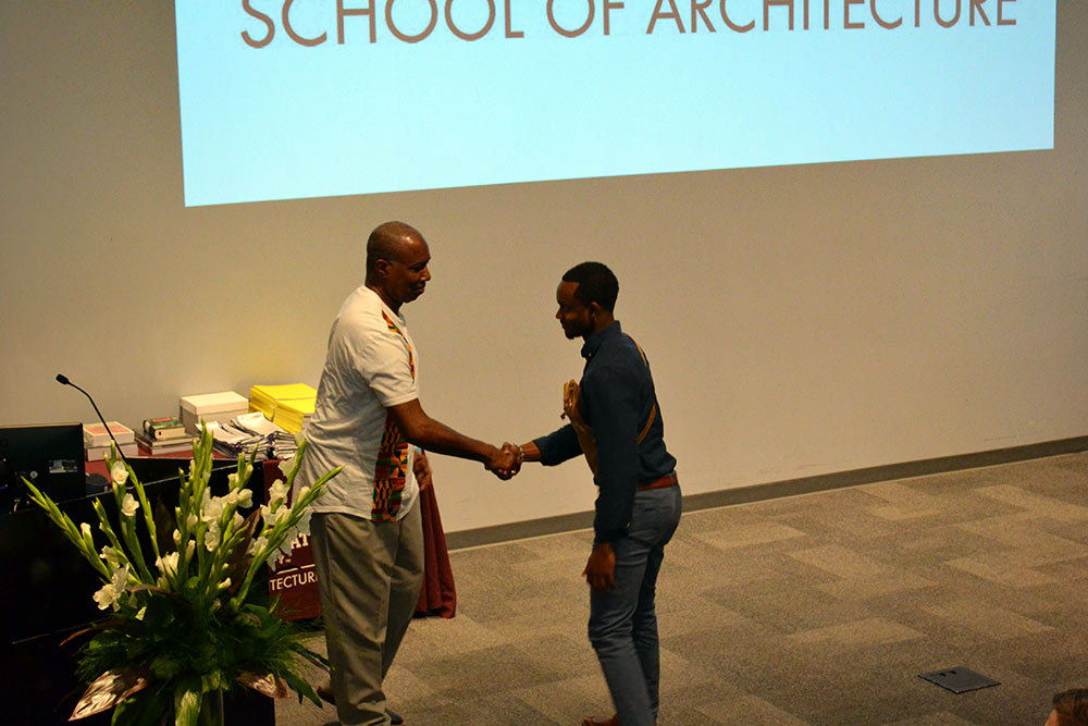 Charles Rounds, receives the Field Trip Sketch Book Award from Dr. Christopher Hunter