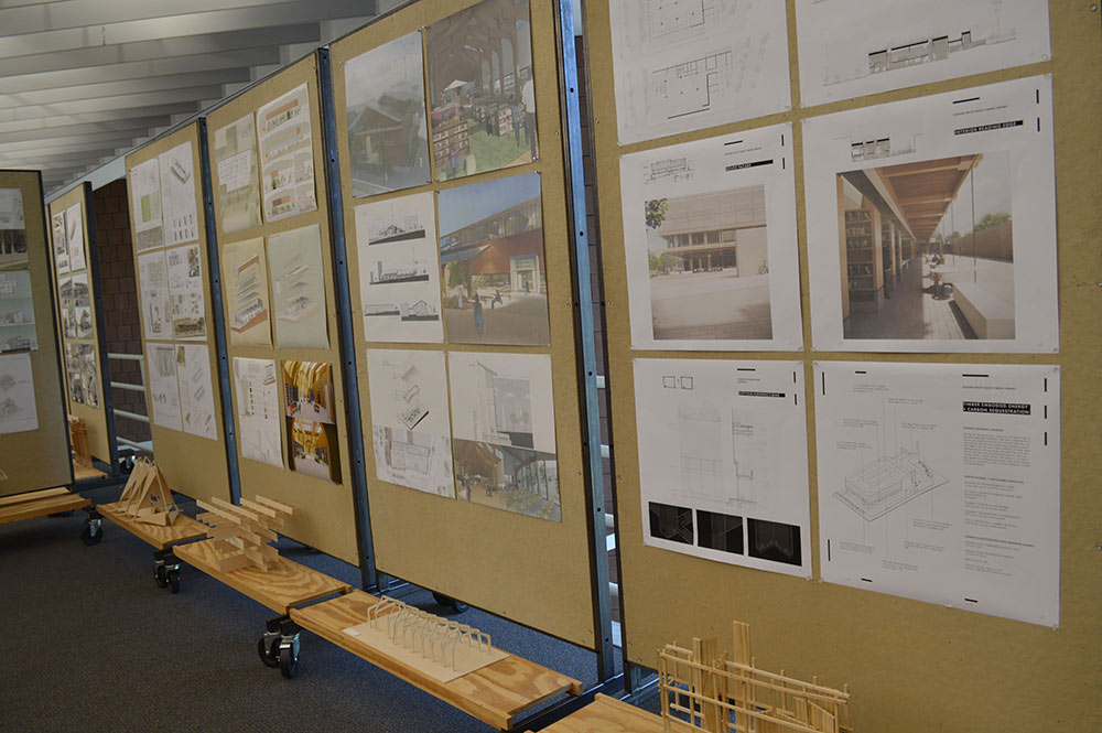 The gallery is lined with pin up boards that feature images and information on some of the projects.