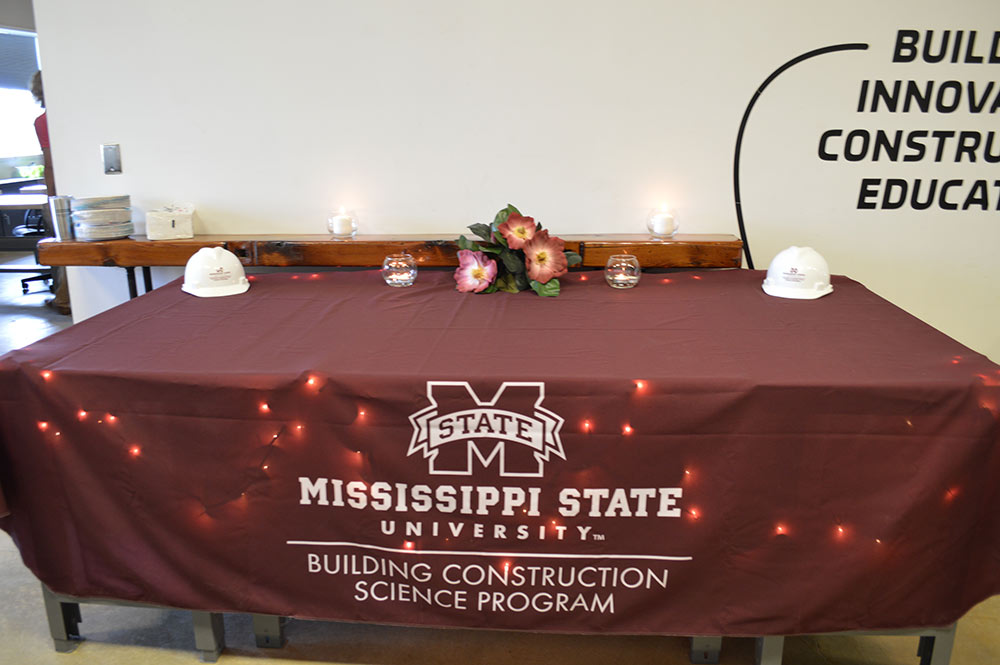A table draped with a MSU table cloth and has graduation decorations on it.