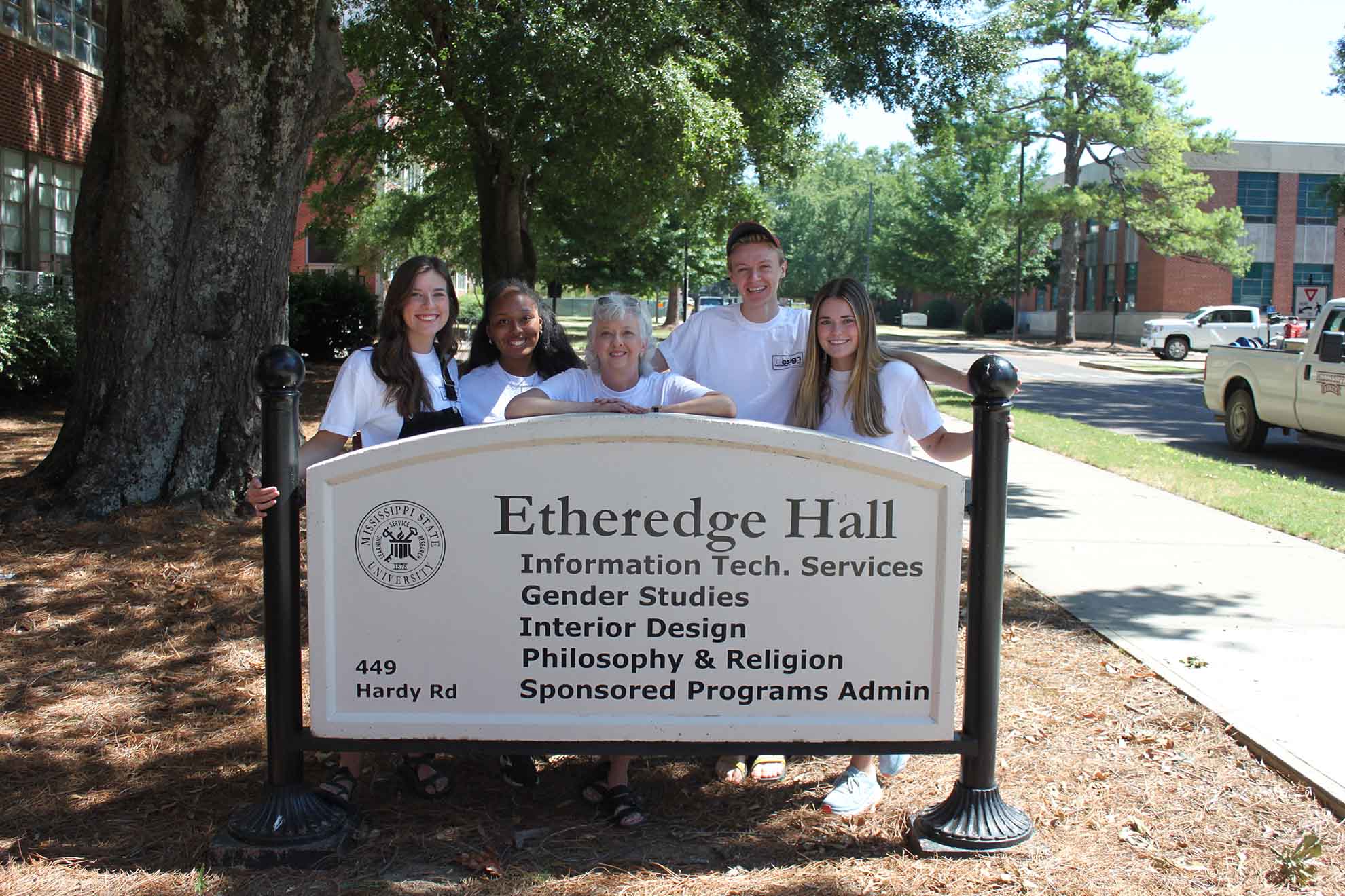 The campers take a picture with the Etheredge sign.