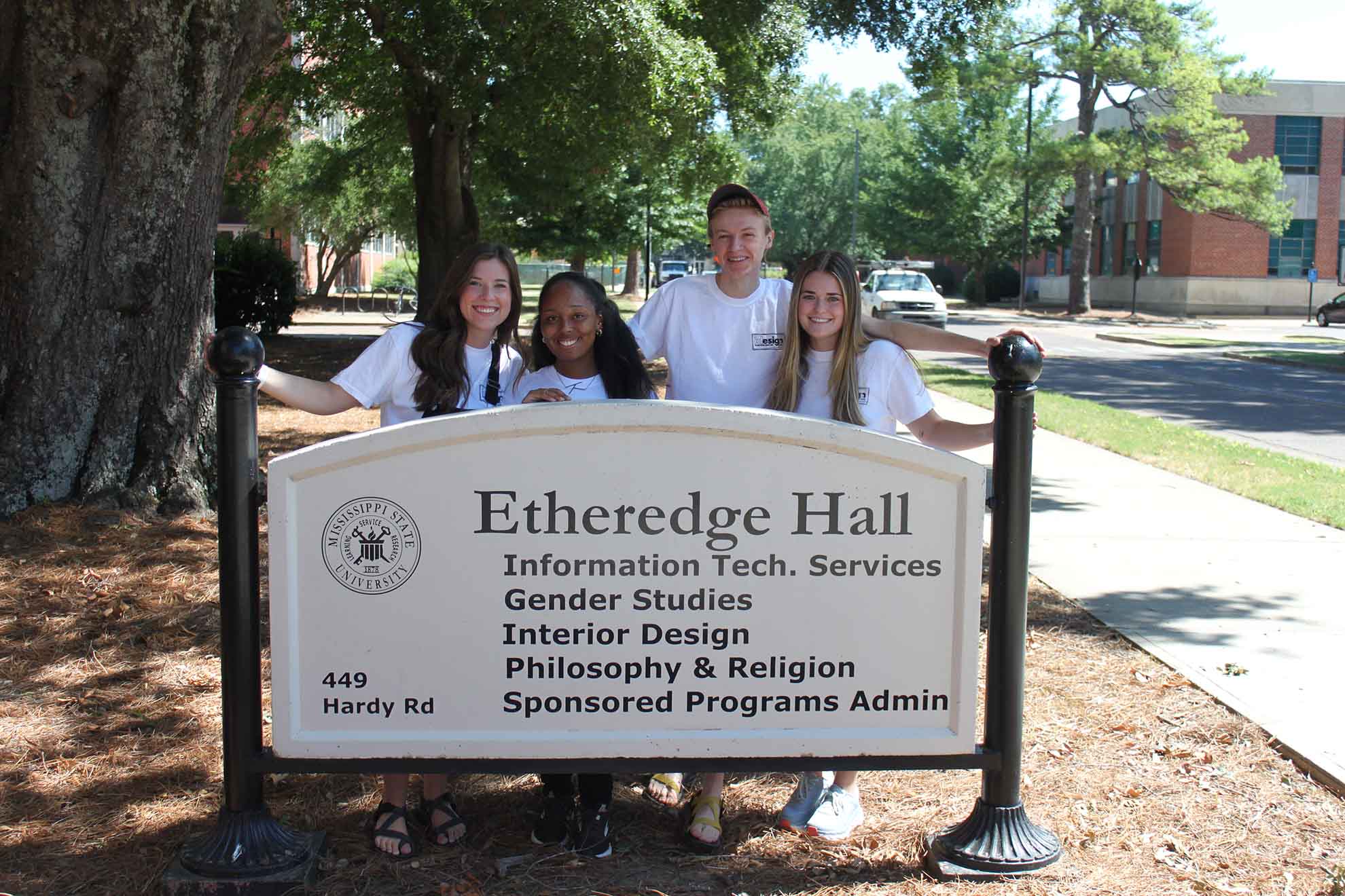 The campers take a picture with the Etheredge sign.