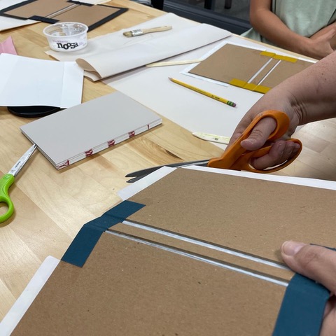The campers use different kinds of paper to create notebooks.
