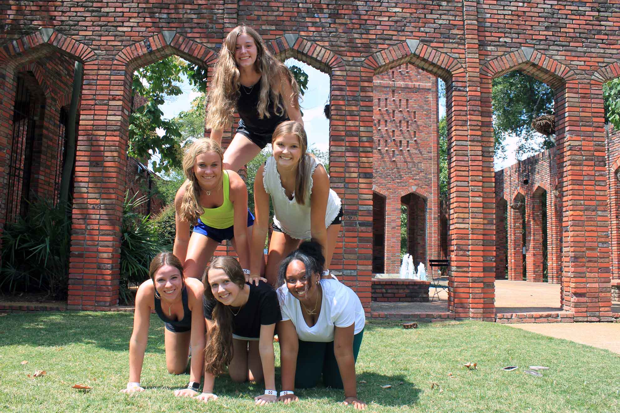 A group of campers make a pyramid.