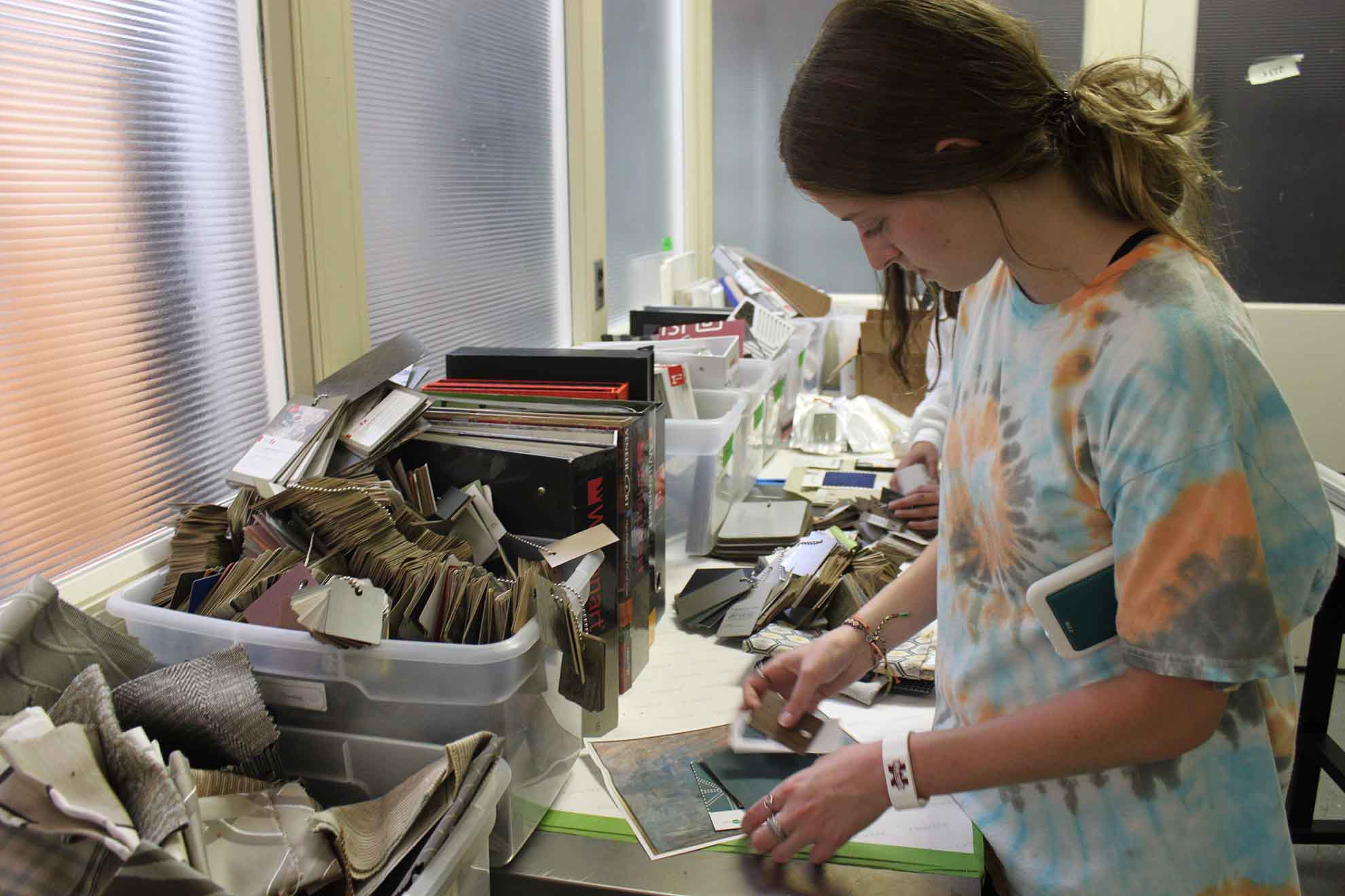 A camper picks materials from the materials library.