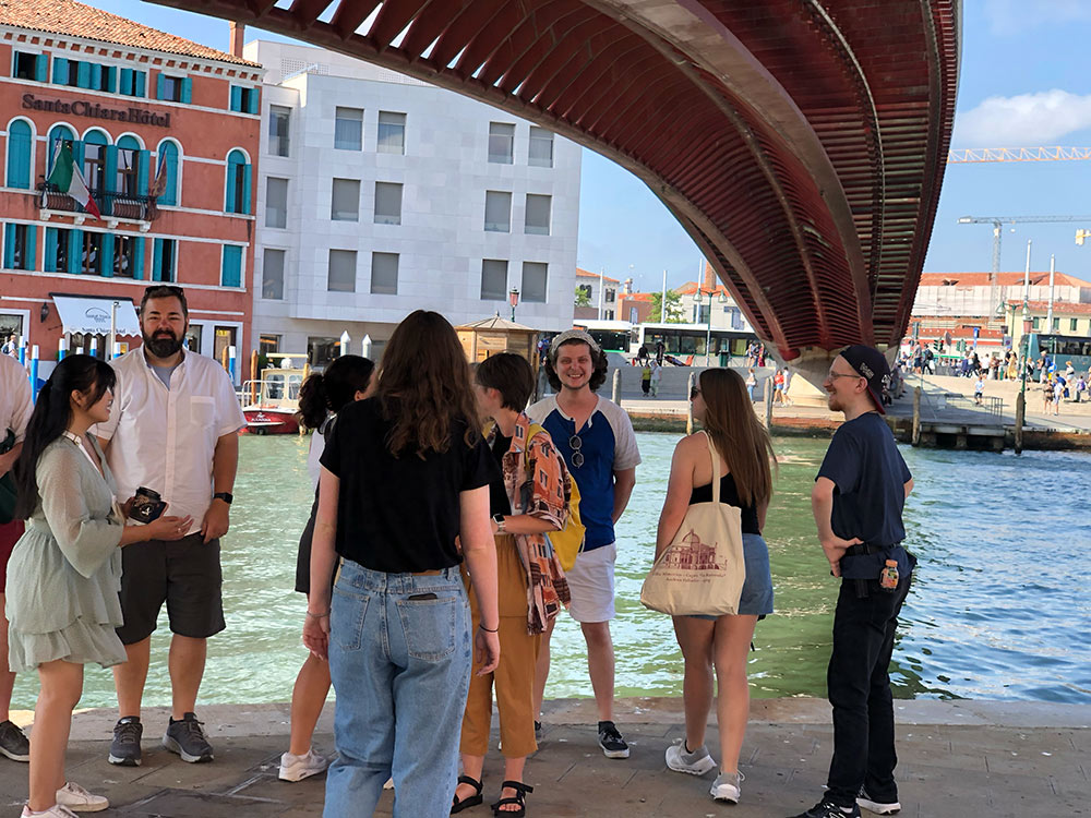 Group gathered by canal under bridge