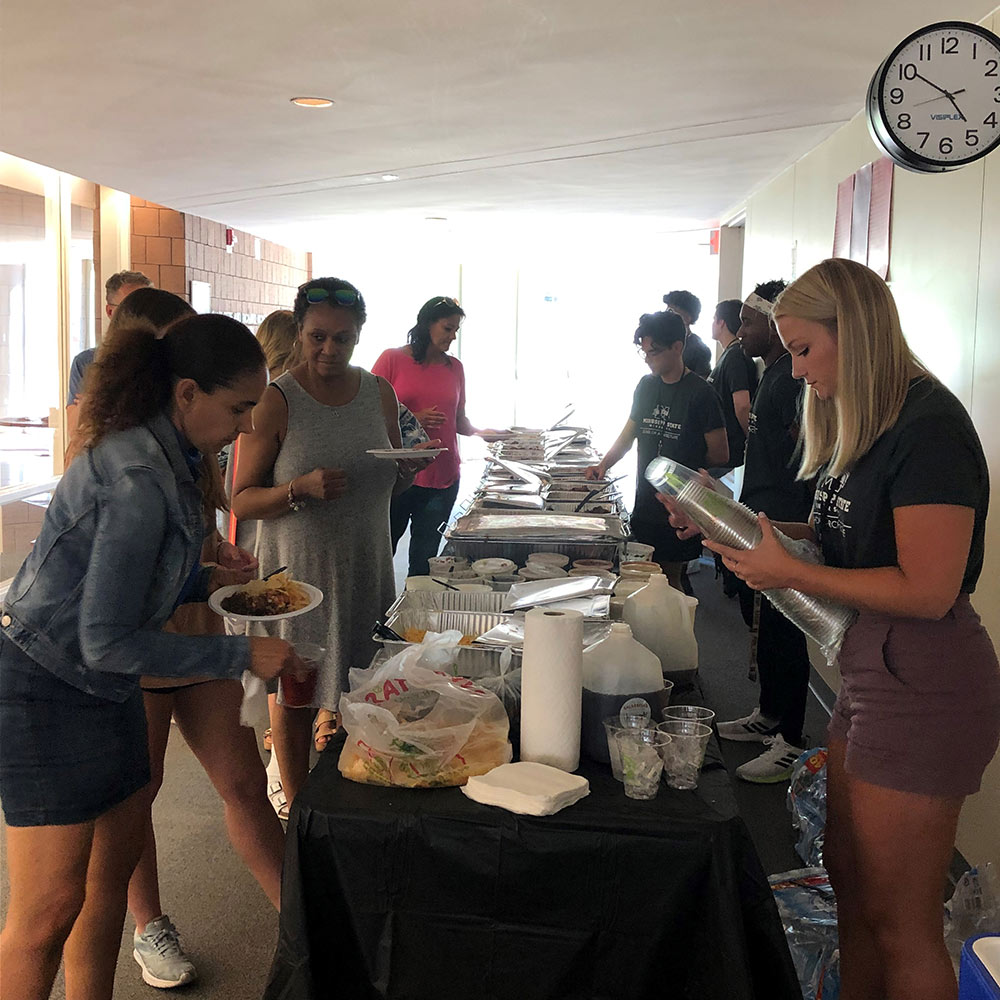 Design Discovery students and families get lunch from buffet style spread