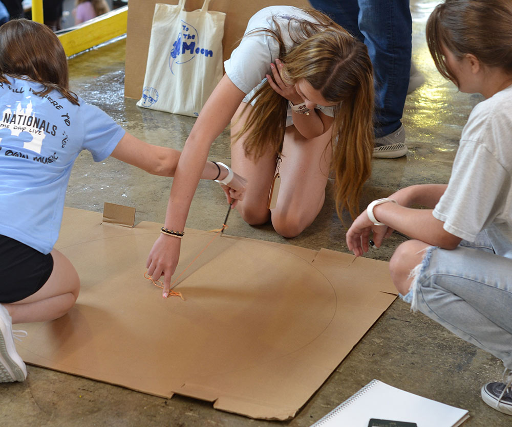Design Discovery campers trace a perfect circle on their cardboard.