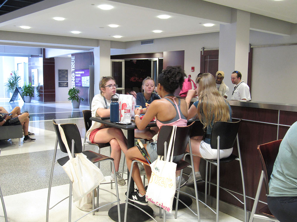 Design Discovery campers sitting in the Union, eating their food.