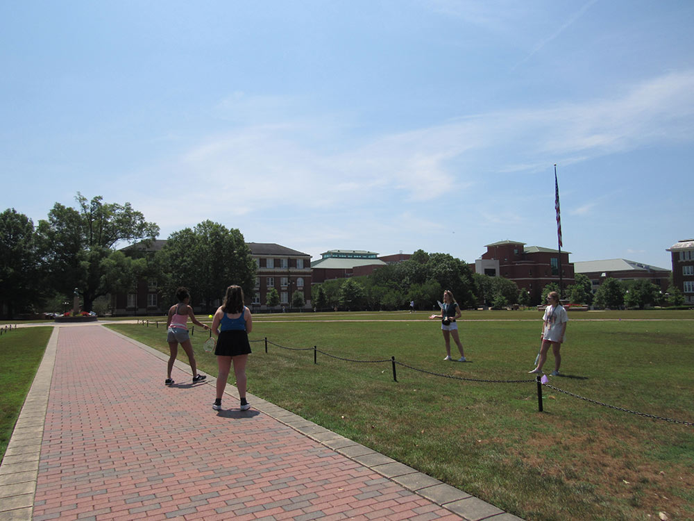 Design Discovery campers play Badminton outside on the Drill field.