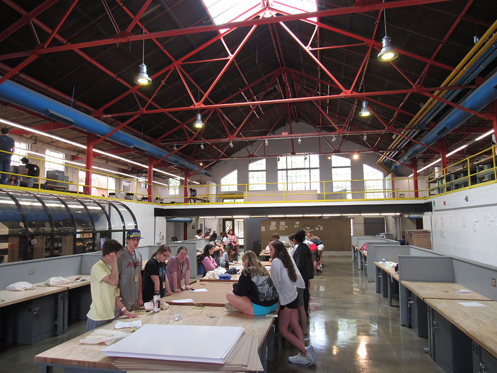 View of Barn filled with Design Discovery campers working on their projects at the desks..