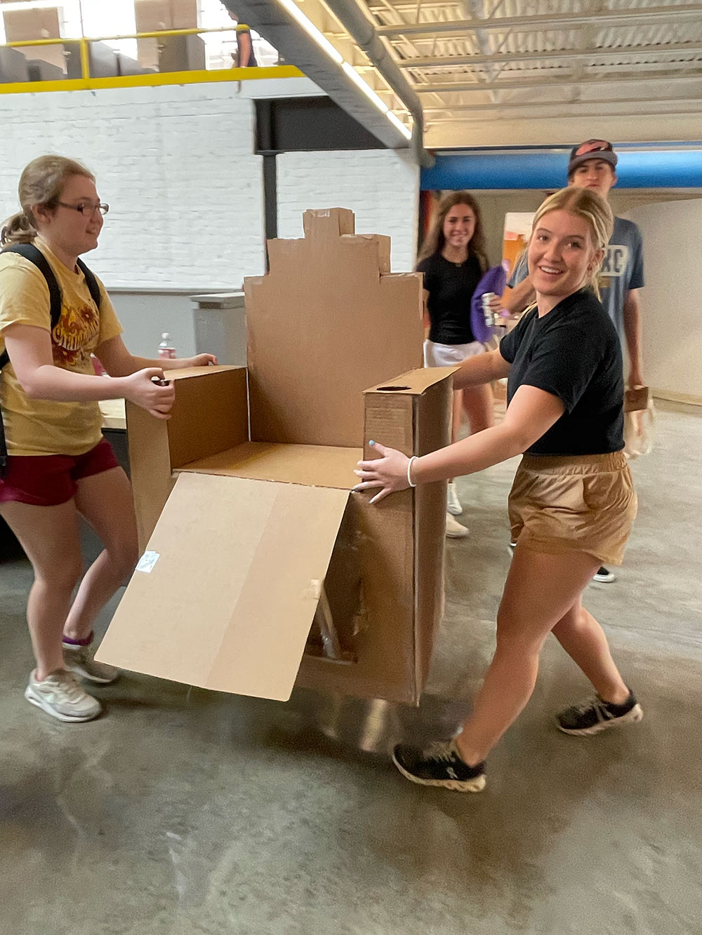 Design Discovery campers carrying their cardboard chair project.