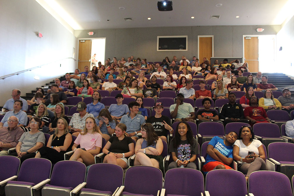 Design Discovery campers wait in the auditorium for a presentation.