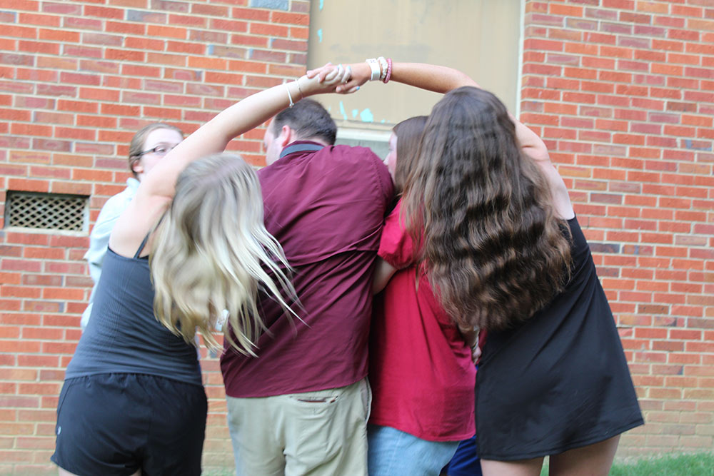 Design Discovery campers and student counselors untangle themselves in the human knot game.