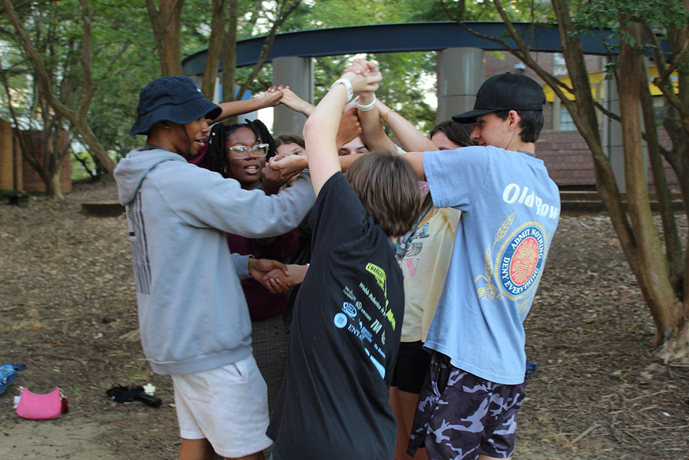 Design Discovery campers and student counselors untangle themselves in the human knot game.