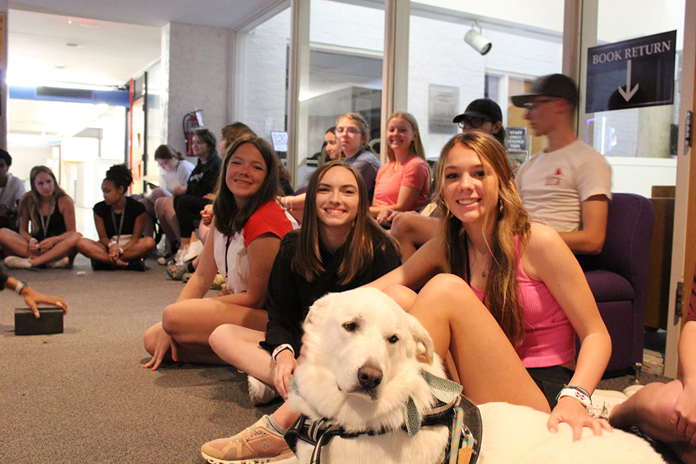 Group of Design Discovery campers pose for a picture with a dog.