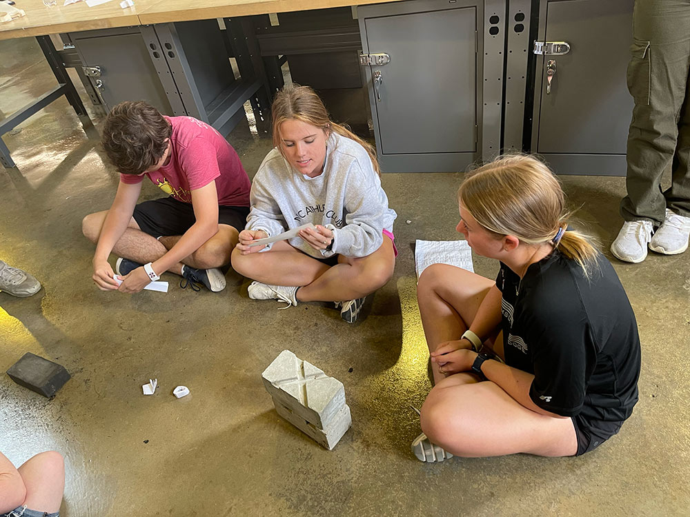 Group of Design Discovery campers working with bricks and paper in Barn.